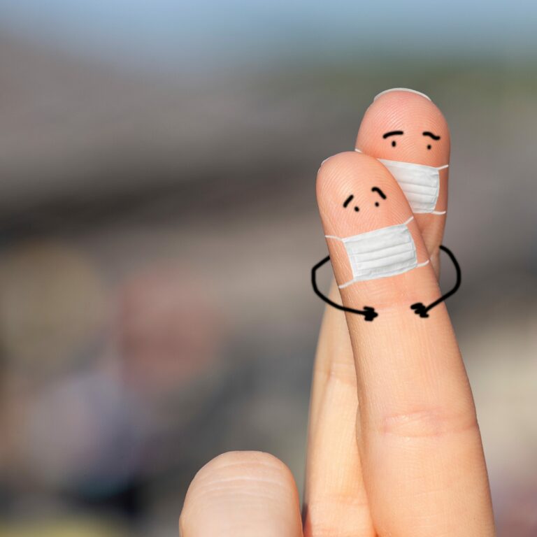 2 Finger mit kleinen Masken auf